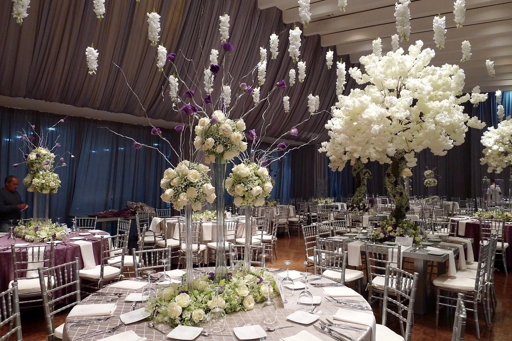 Árboles de flores blancas sobre mesas de boda