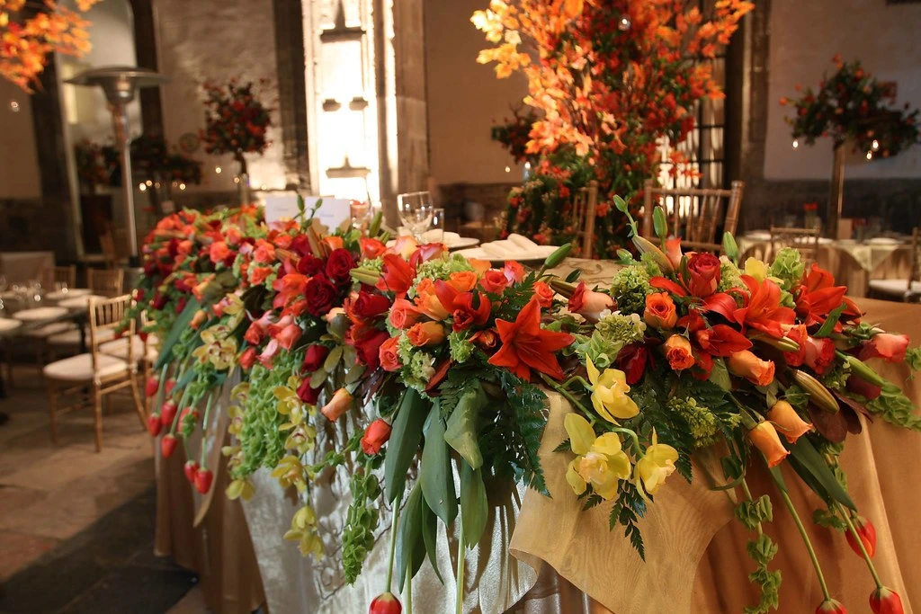 Arreglo floral otoñal con flores rojas y naranjas