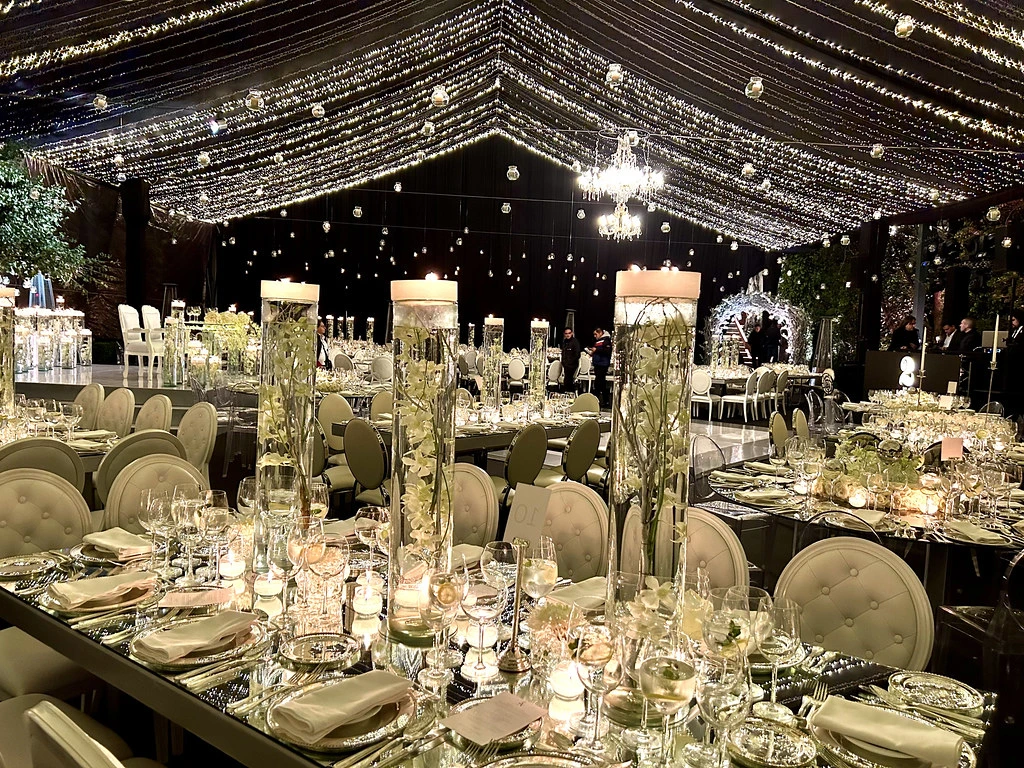 Carpa de boda con cielo de luces y centros de mesa de cristal