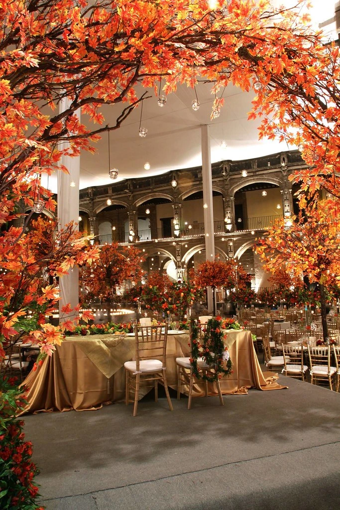Patio colonial decorado con árboles de follaje naranja para una boda
