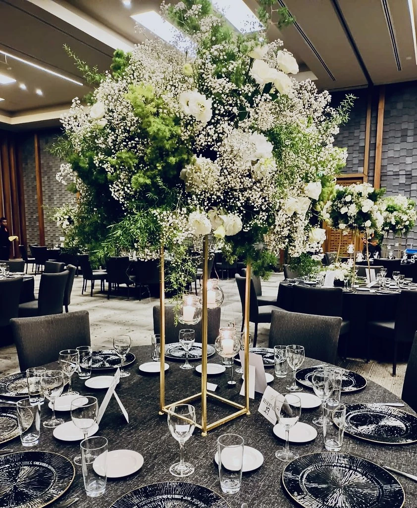 Arreglos florales blancos y verdes sobre mesas de boda